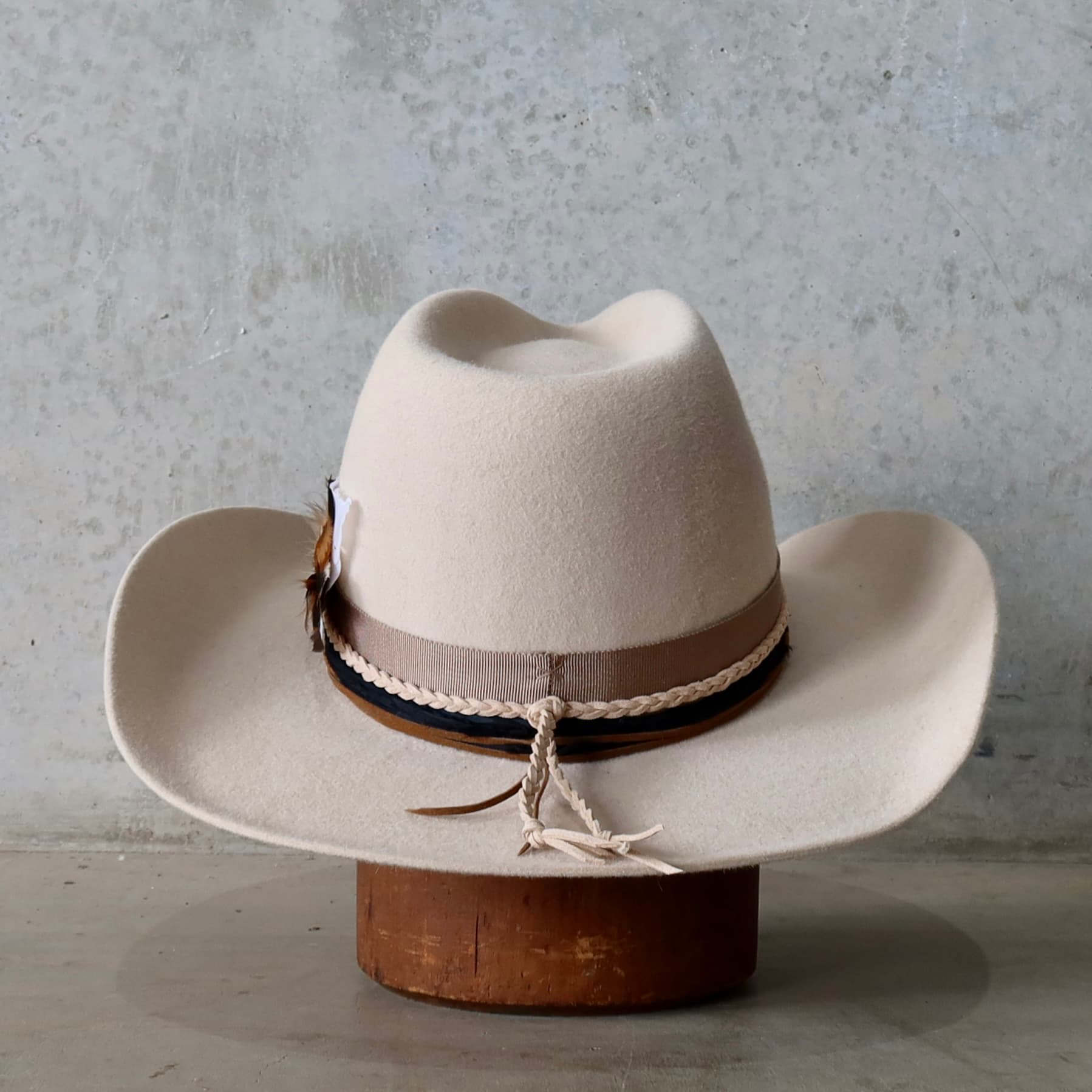 Back view of the beige felt cowboy hat Casey Beige by PHYLLi Designs featuring plaited nude suede tie and layered trim wraps.