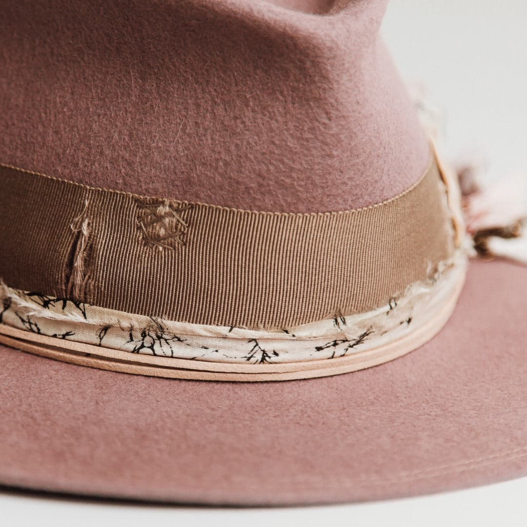 Close up detail of the Celia felt hat showing distressed taupe grosgrain band and patched darning.