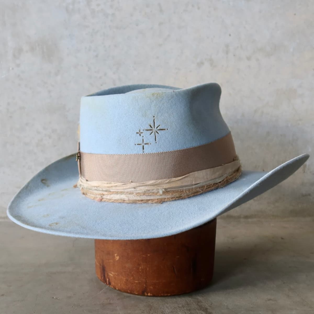 Back right angle of the Crystal Blue felt cowboy hat Clareville Limited Edition by PHYLLi Designs featuring burnt branded patterns on the crown.