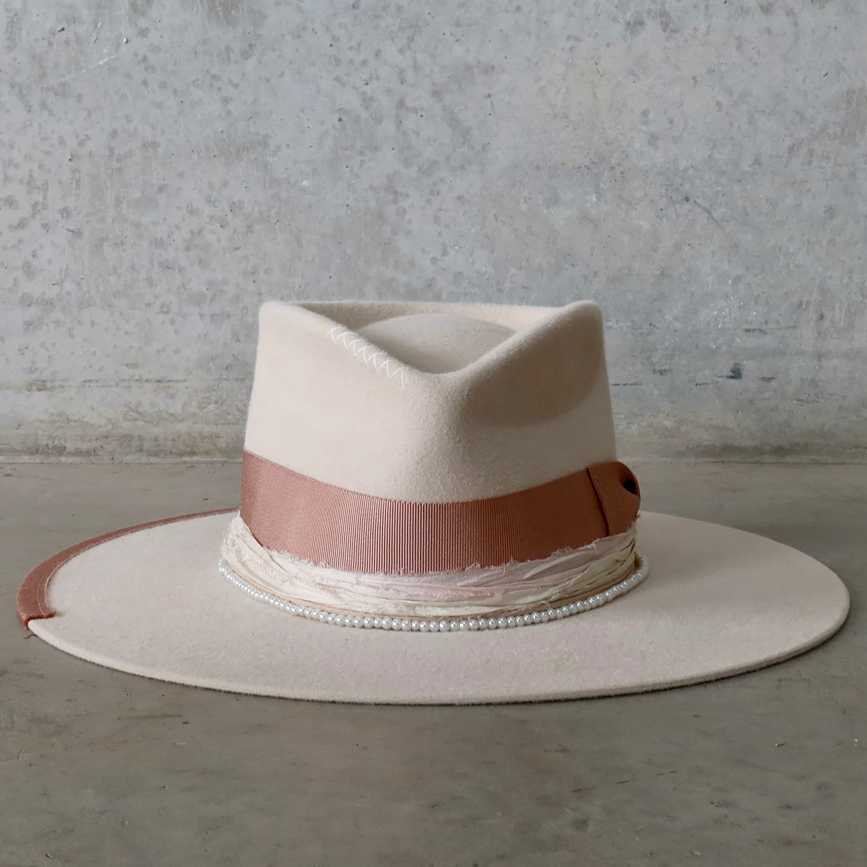 Beige felt hat Clementine by PHYLLi Designs with dirty rose Japanese grosgrain bow band and pearl hat necklace.