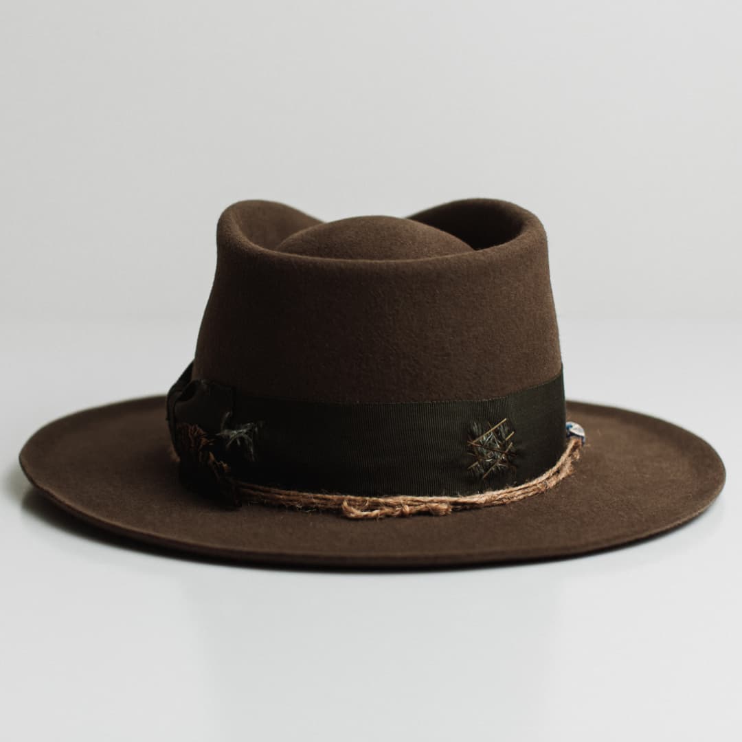 Back view of the Congo dirty olive felt hat by PHYLLi Designs featuring distressed moss darned patches and twine wraps.