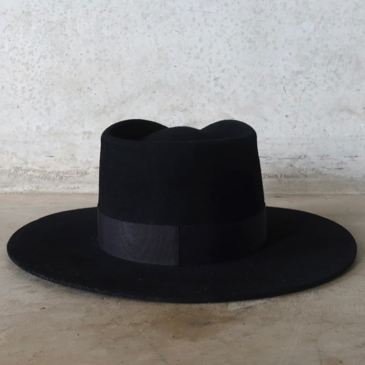 Back view of the black felt hat Core Black by PHYLLi Designs featuring interchangeable black Japanese grosgrain band.