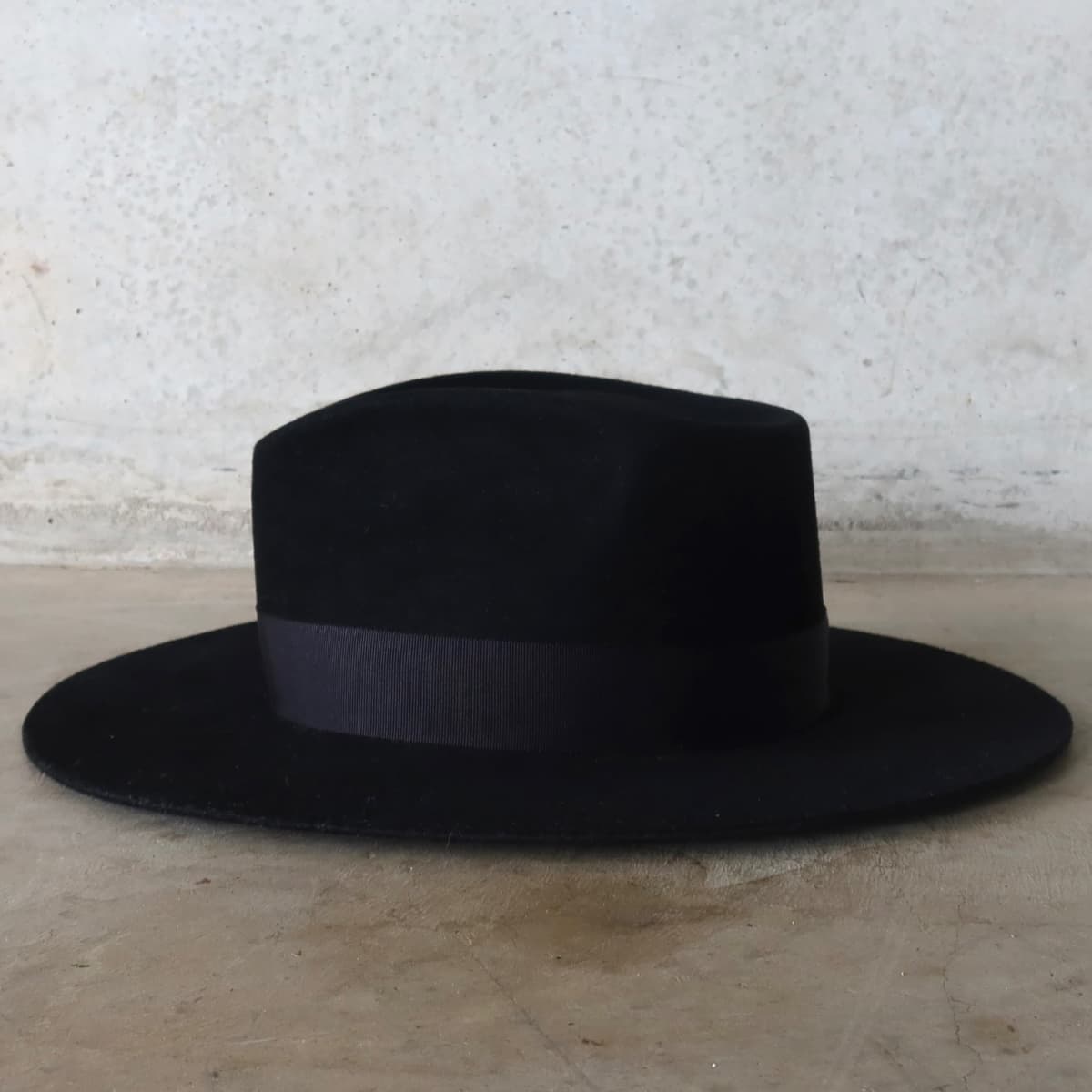 Left side view of the black felt hat Core Black by PHYLLi Designs with black Japanese grosgrain band.