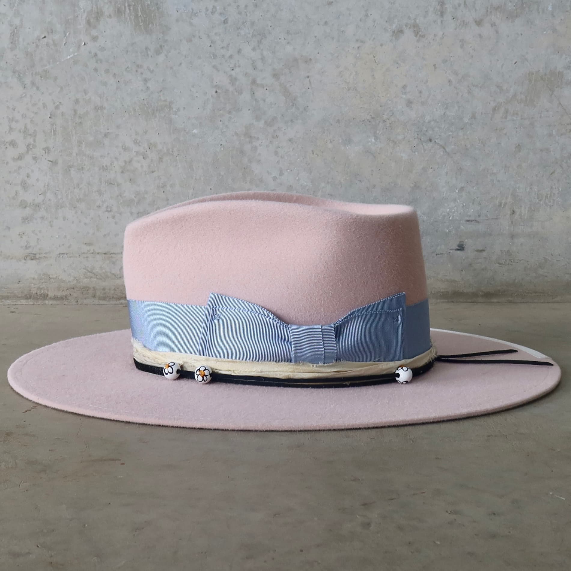 Left side view of the baby pink felt hat Daisy by PHYLLi Designs featuring cornflower grosgrain double bow band.