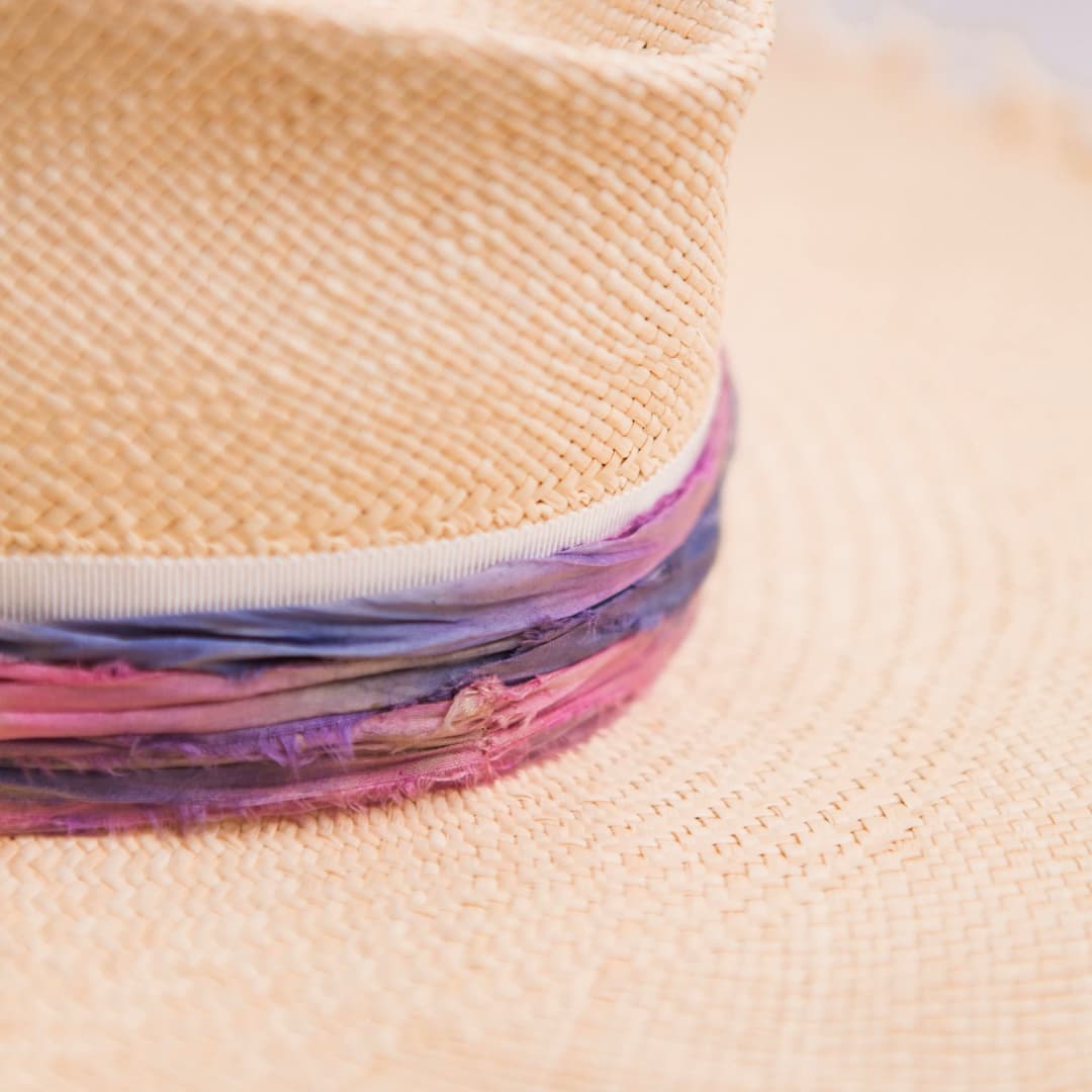 Close up detail of the Delfina Panama hat showing cornflower and bubblegum tie dye sari silk trimming.