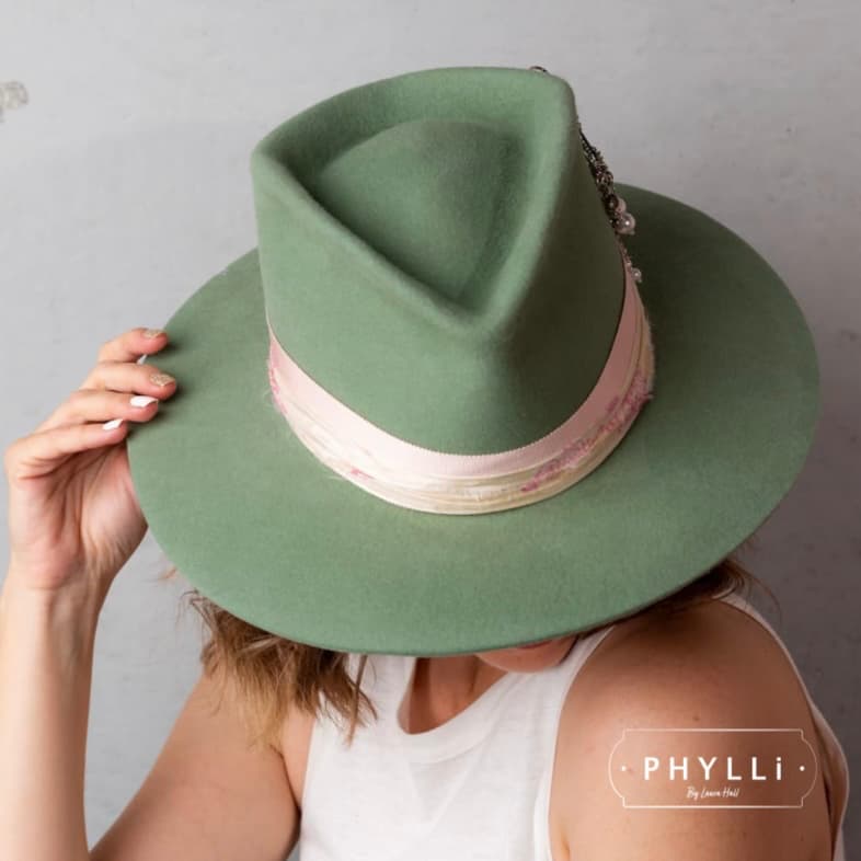 Woman wearing the Diamonds & Pearls eucalyptus felt hat by PHYLLi Designs with sherbet pink grosgrain band and cream sari silk trim.