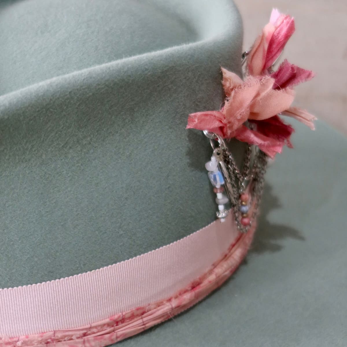 Close up detail of the Diamonds & Pearls – Pink felt hat showing strawberry and candy sari silk trimming.