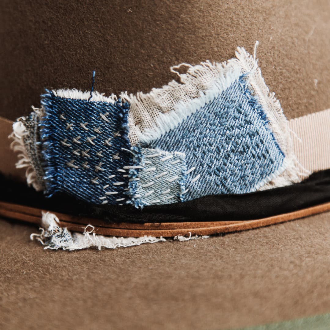Close up detail of the Dirty Jane felt hat showing wabi sabi denim and linen patch with visible hand stitching.