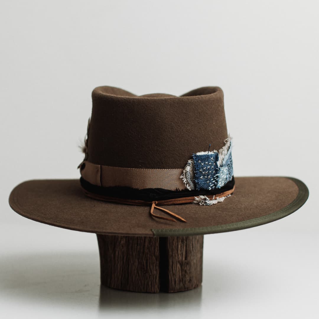 Back view of the Dirty Jane dirty olive felt hat by PHYLLi Designs featuring taupe grosgrain ribbon band and double brim stitch in dark green.