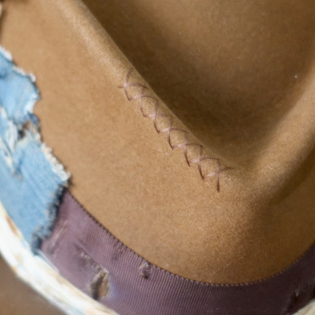 Close up detail of the Duke Limited Edition felt hat showing chocolate hand-stitched cross detail on the crown.