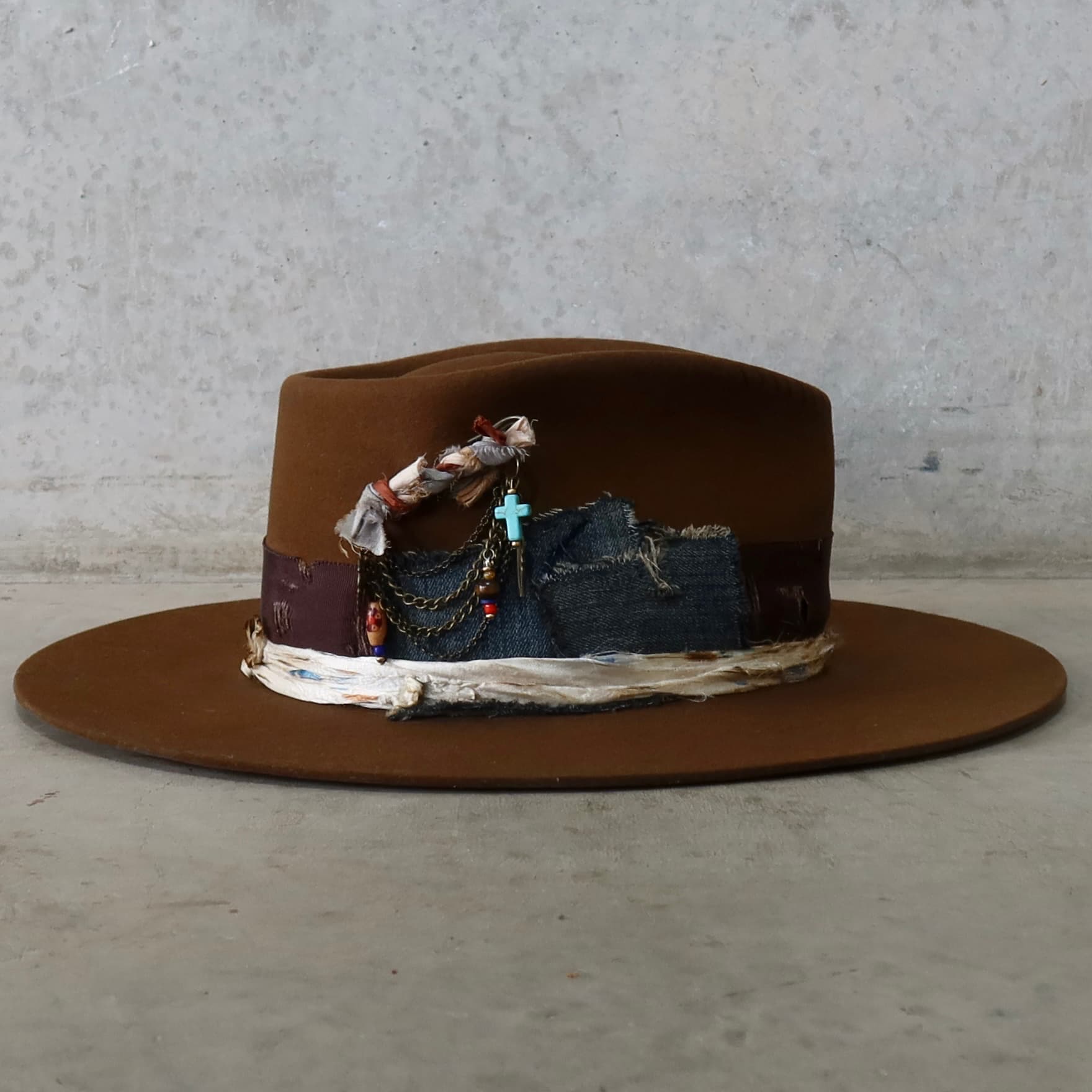 Right side view of the caramel felt hat Duke Limited Edition by PHYLLi Designs with denim patch trims and bronze chunky hat pin.