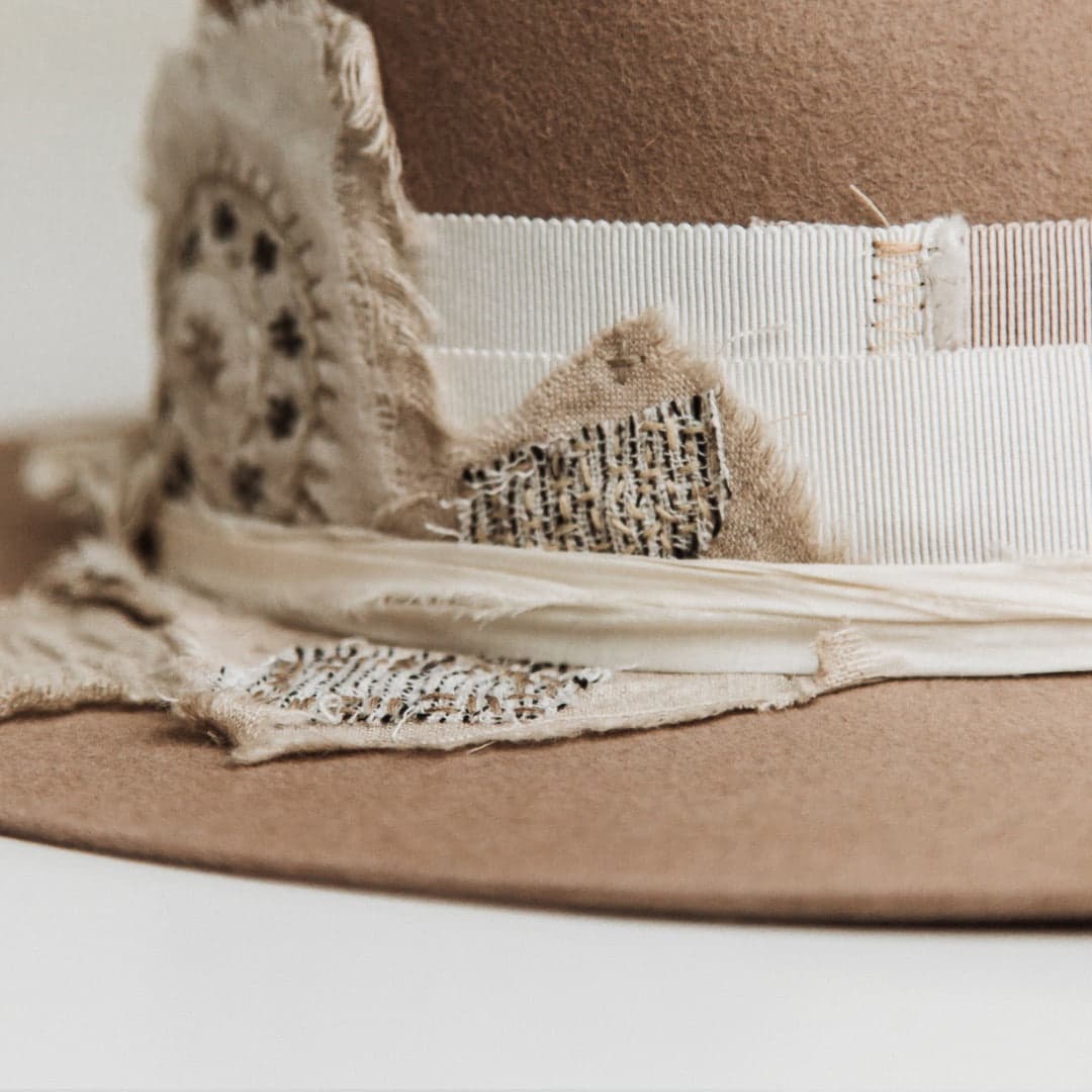 Close up detail of the Enso felt hat showing wabi sabi fabric patchwork with visible hand stitching and ivory sari silk trimming.