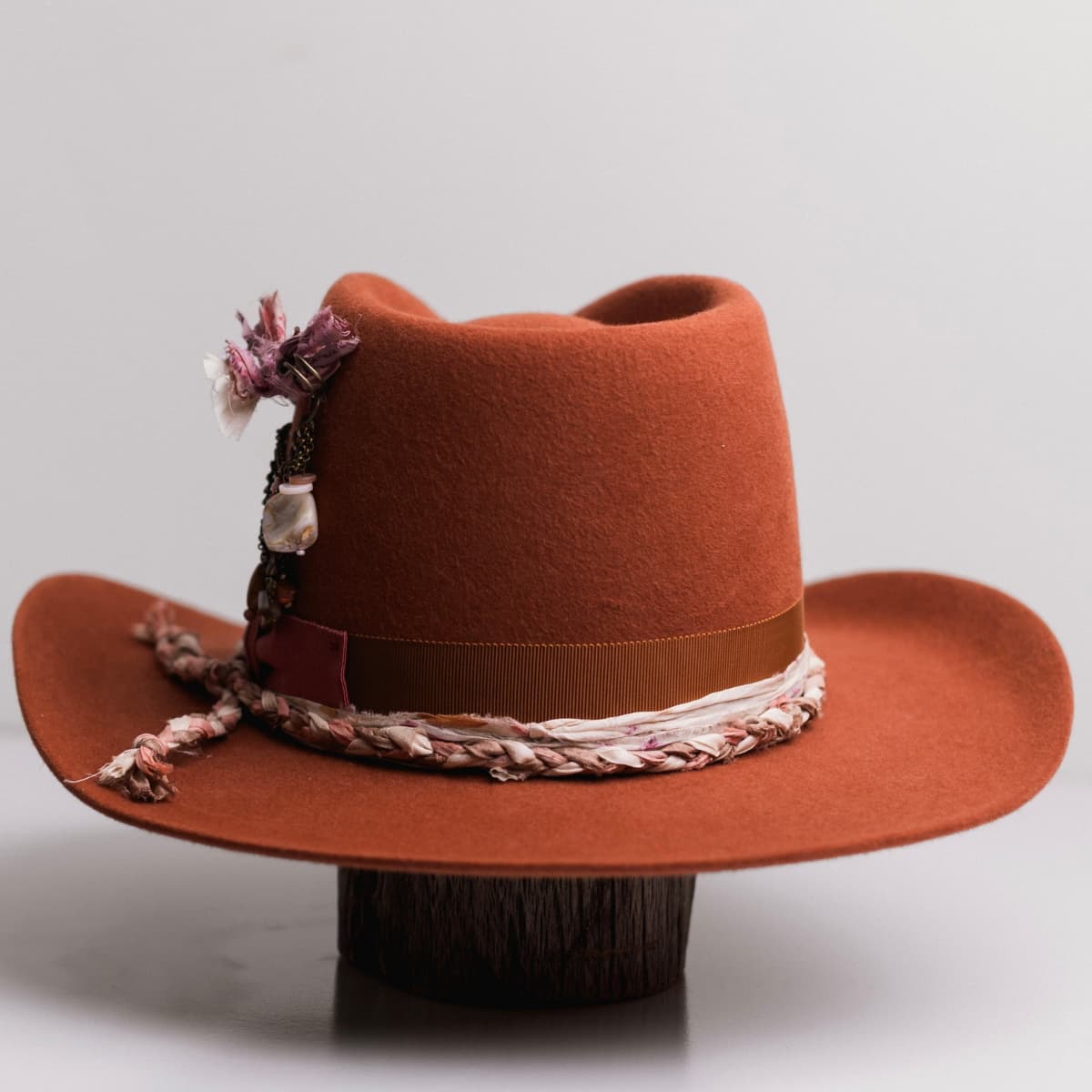 Back view of the Spiced Pumpkin felt cowboy hat Evans by PHYLLi Designs featuring plaited sari silk trimming in salmon, cream and blush.