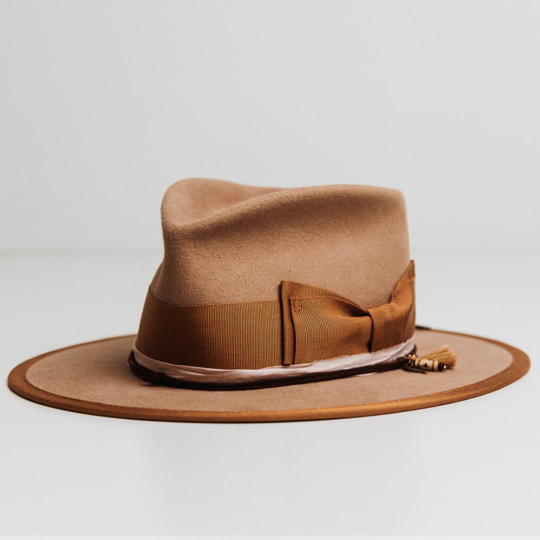 Feuille Morte Camel felt hat showing Copper grosgrain double bow band and charm cluster with tassel and charms.