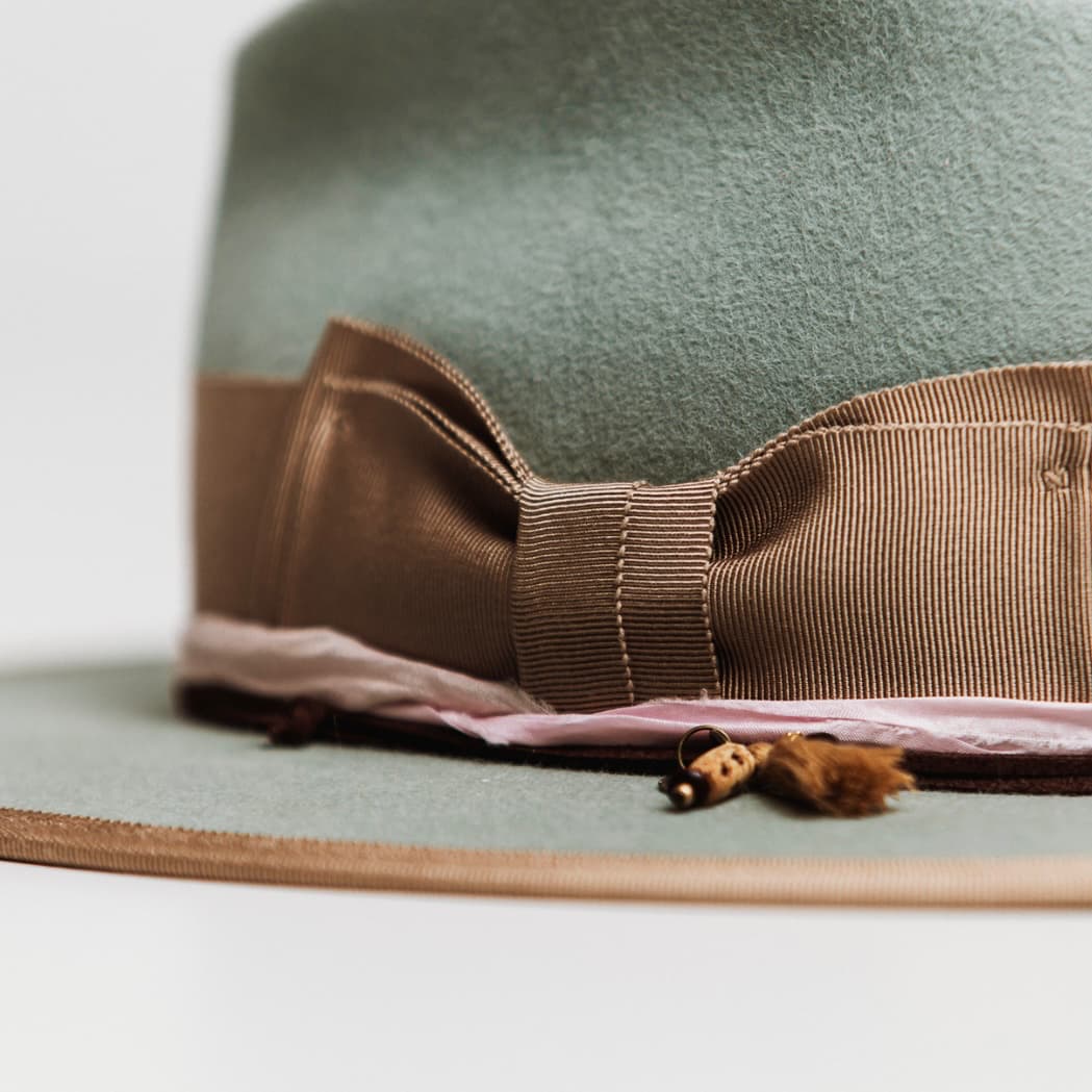 Detail of Feuille Morte Sage felt hat showing rose sari silk trim and chocolate suede string.
