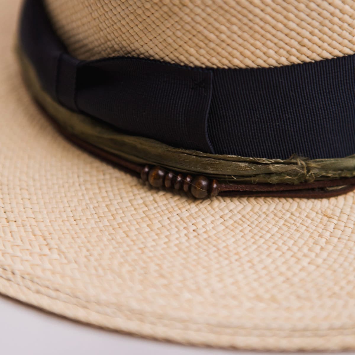 Close up detail of the Figueras Panama hat showing dark navy double brim stitch on natural toquilla straw.