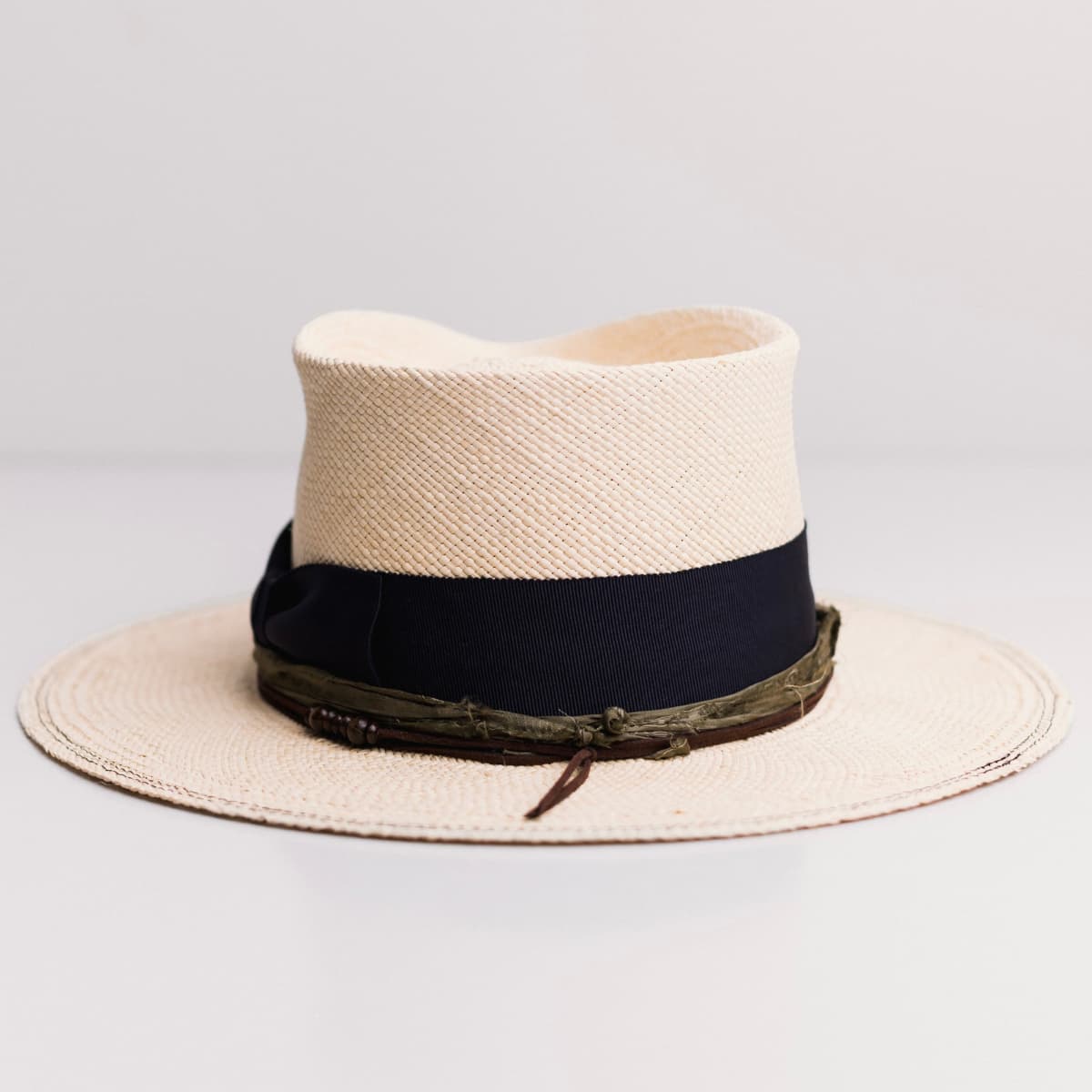 Back view of the Natural Panama hat Figueras by PHYLLi Designs featuring chocolate suede string with large wooden bead pattern.