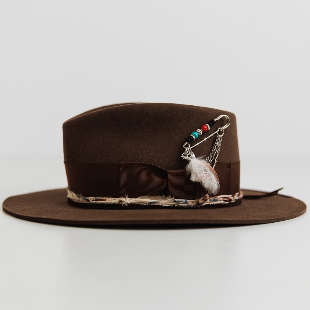 Left side view of the Fly Fisher Havana felt hat by PHYLLi Designs with chunky hat pin and sari silk trim.