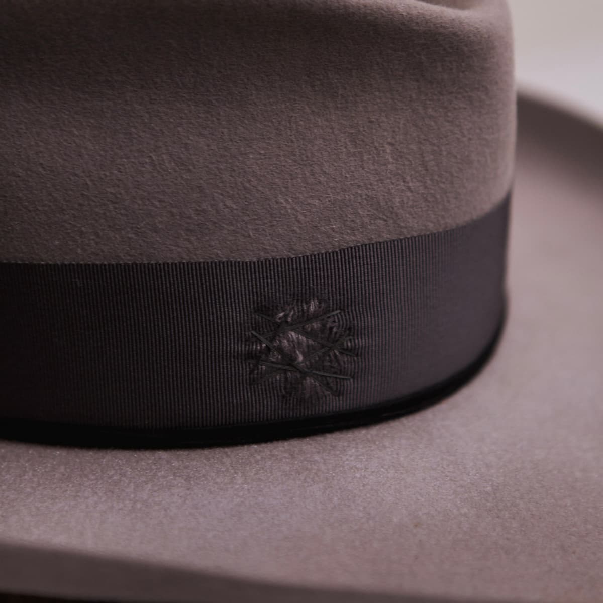 Close up detail of the Franco felt hat showing turquoise stud set into the grosgrain bow band.
