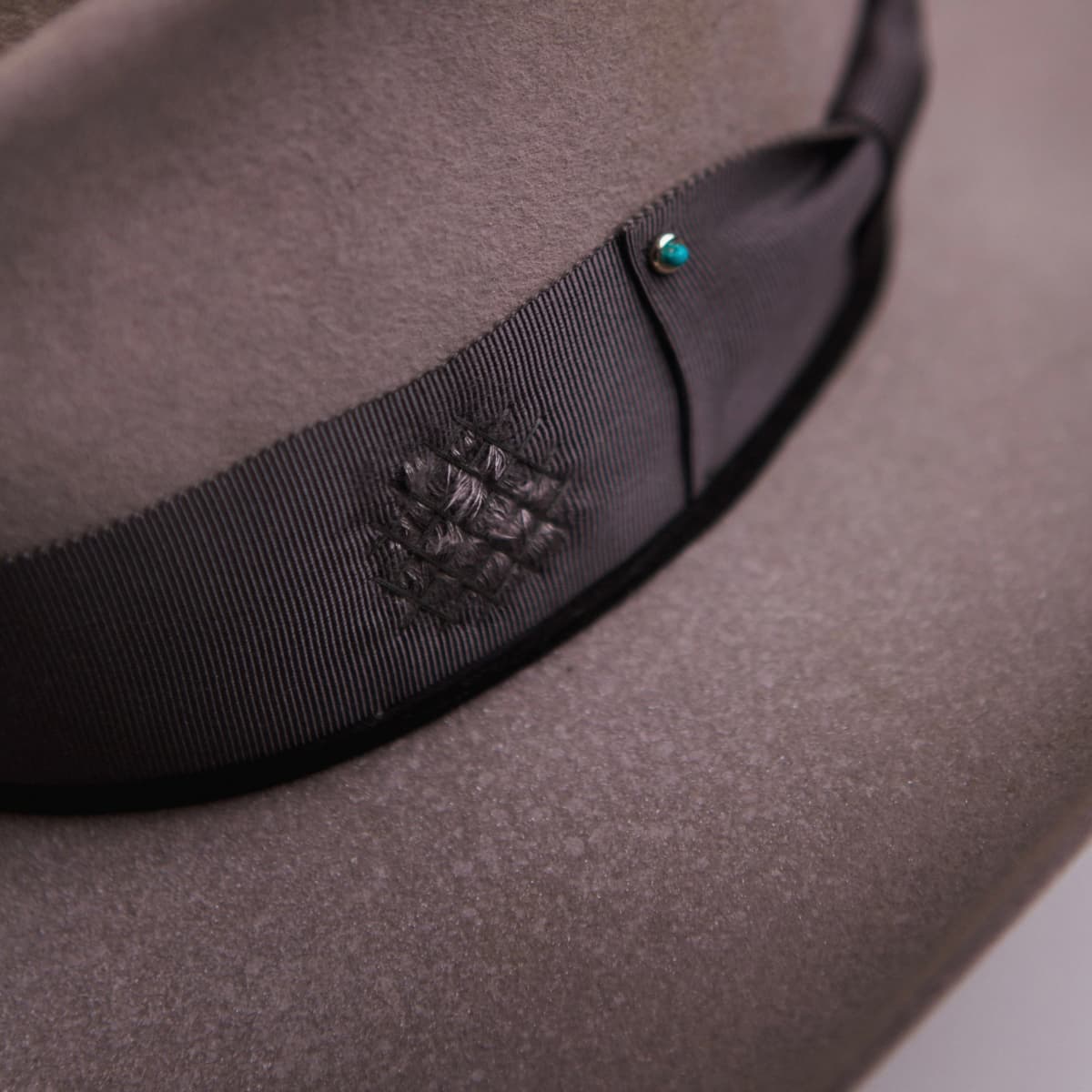 Close up detail of the Franco felt hat showing distressed slate grosgrain band with hand darned patch stitching.