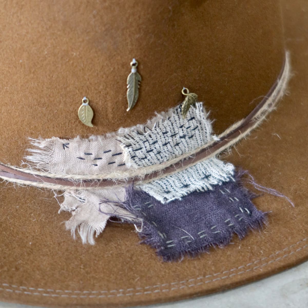 Close up detail of the George Limited Edition felt hat showing Wabi Sabi linen patchwork with hand darning.
