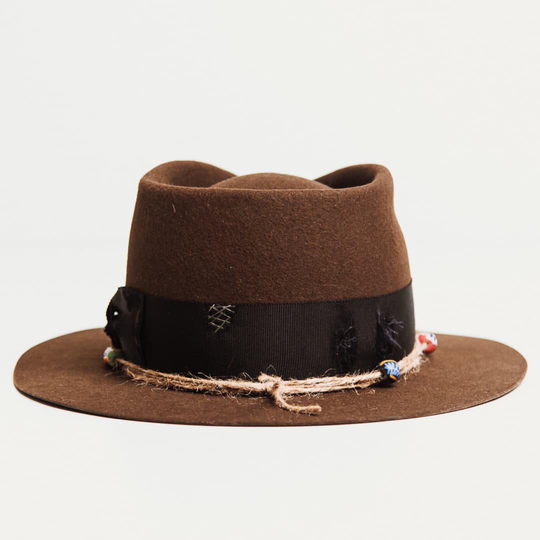 Back view of the Ghana chocolate felt hat by PHYLLi Designs featuring steel grey hand-darned patches on the distressed grosgrain band.
