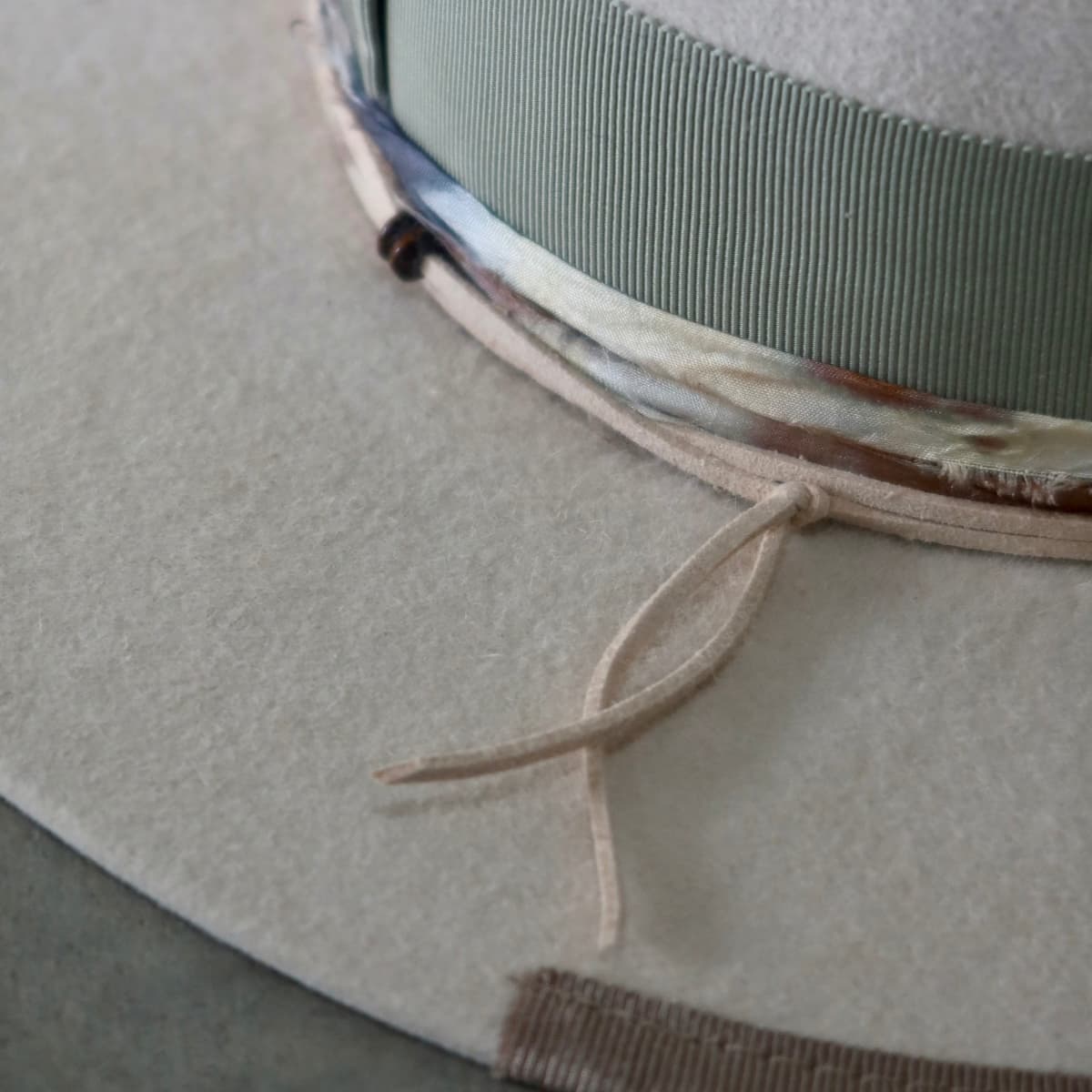 Close up detail of the Grasslands felt hat showing taupe Japanese grosgrain brim trim and nude suede tie.