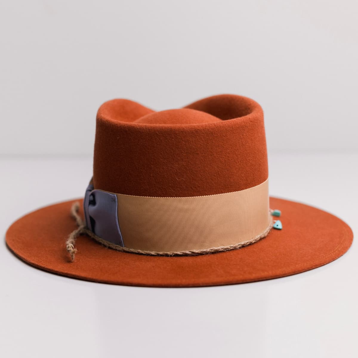 Back view of the Howlit Spiced Pumpkin felt hat by PHYLLi Designs featuring apricot grosgrain band with cornflower bow.