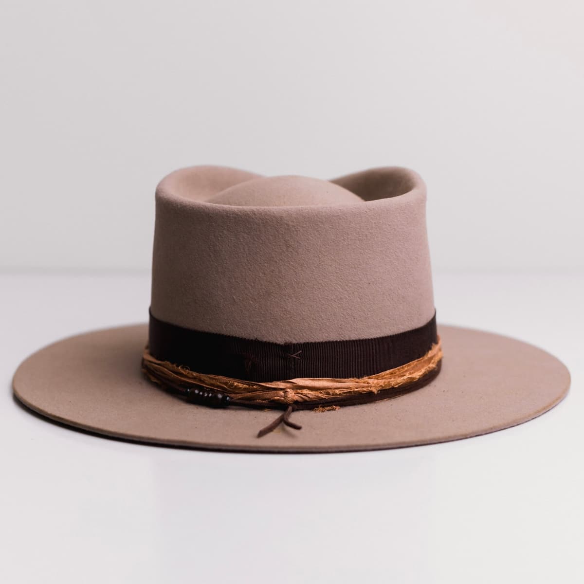 Back view of the Sahara felt hat Hyndman by PHYLLi Designs featuring chocolate suede string with large wooden bead pattern.