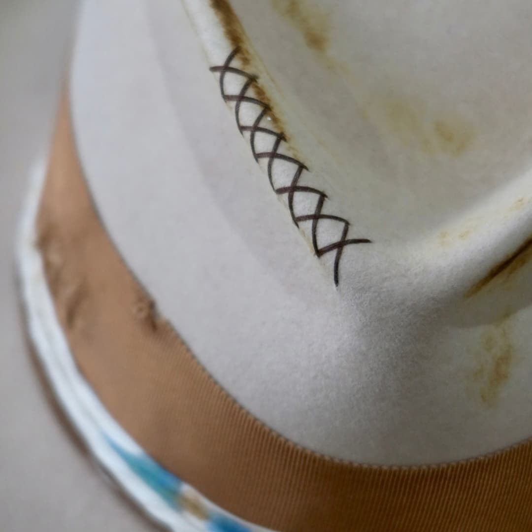 Close up detail of the Iluka cowboy hat showing the dark brown cross stitching on the sand felt crown.