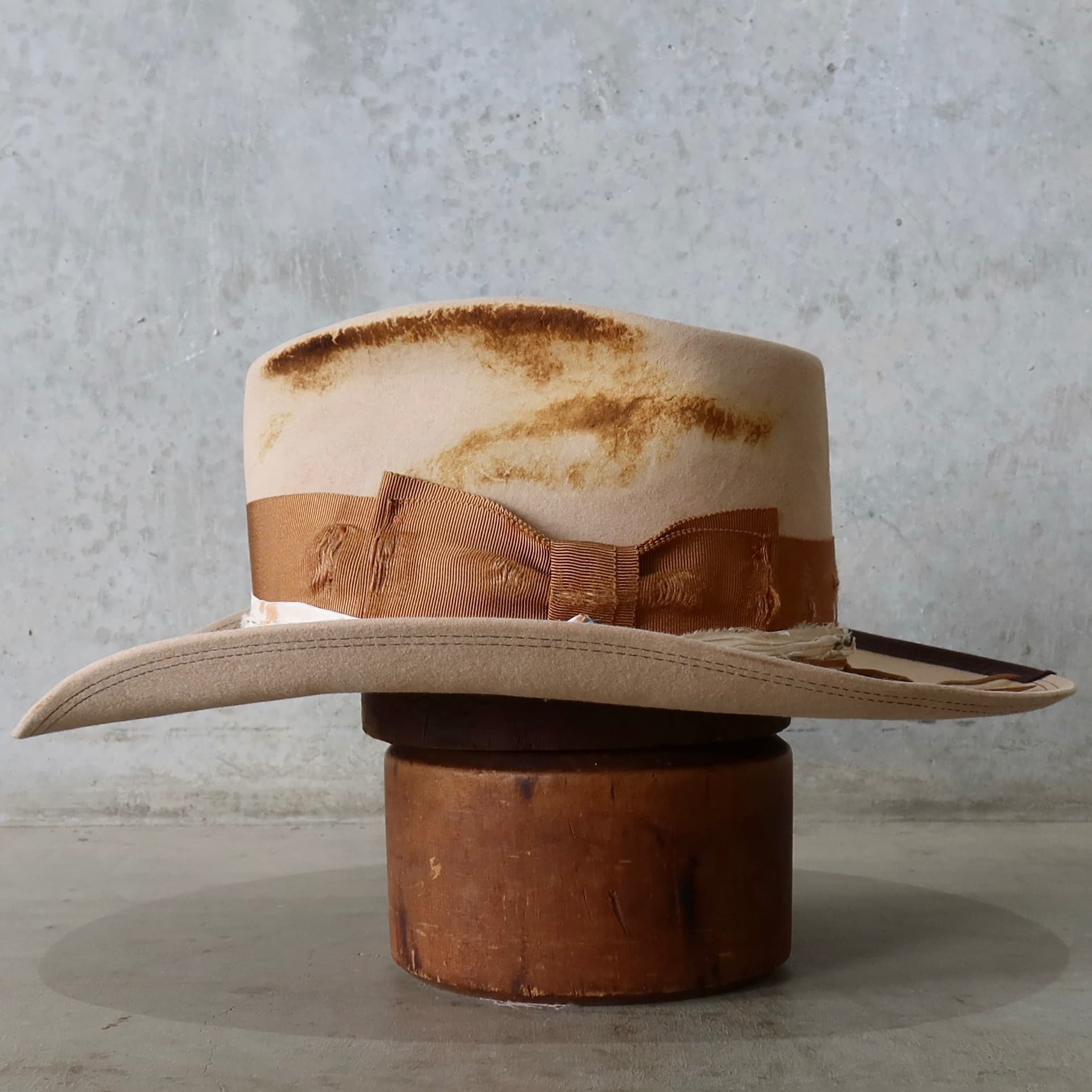 Left side view of the sand cowboy hat Iluka by PHYLLi Designs with copper grosgrain band, speckled sari silk trim and shaped brim.