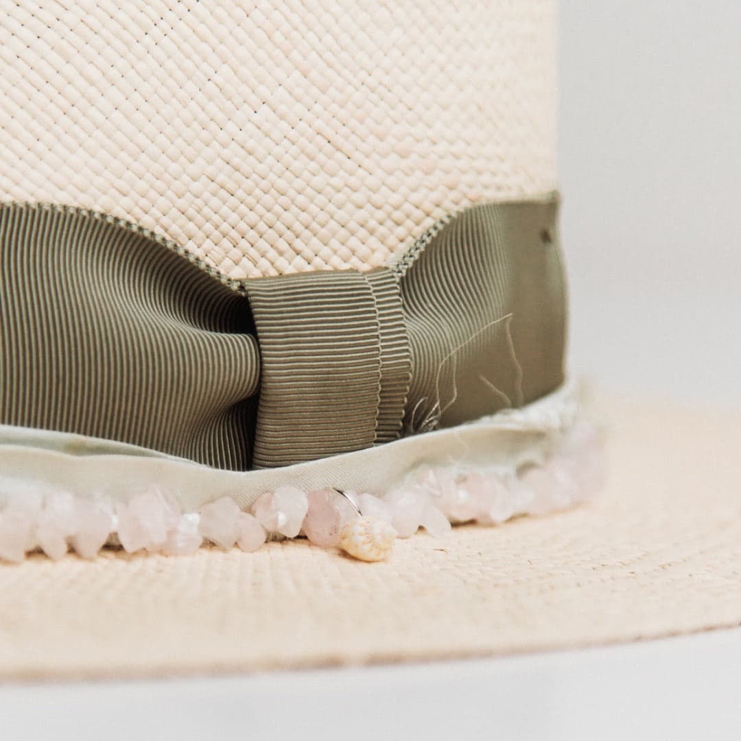 Close up detail of the Isle of Skye Panama hat showing rose quartz hat necklace with single shell charm.