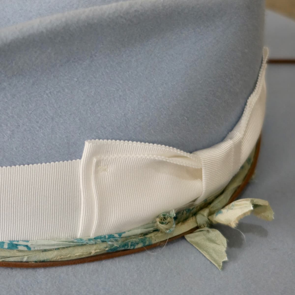 Close up detail of the Jarvis felt hat showing ivory Japanese grosgrain double bow band and sari silk trimming.