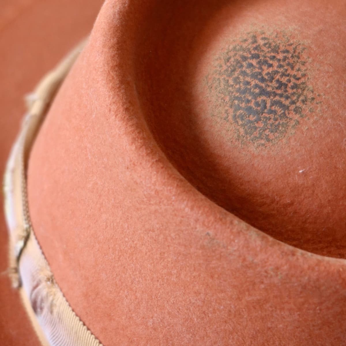 Close up detail of the Karratha felt hat showing distressed Spiced Pumpkin felt crown with vintage wear patina.