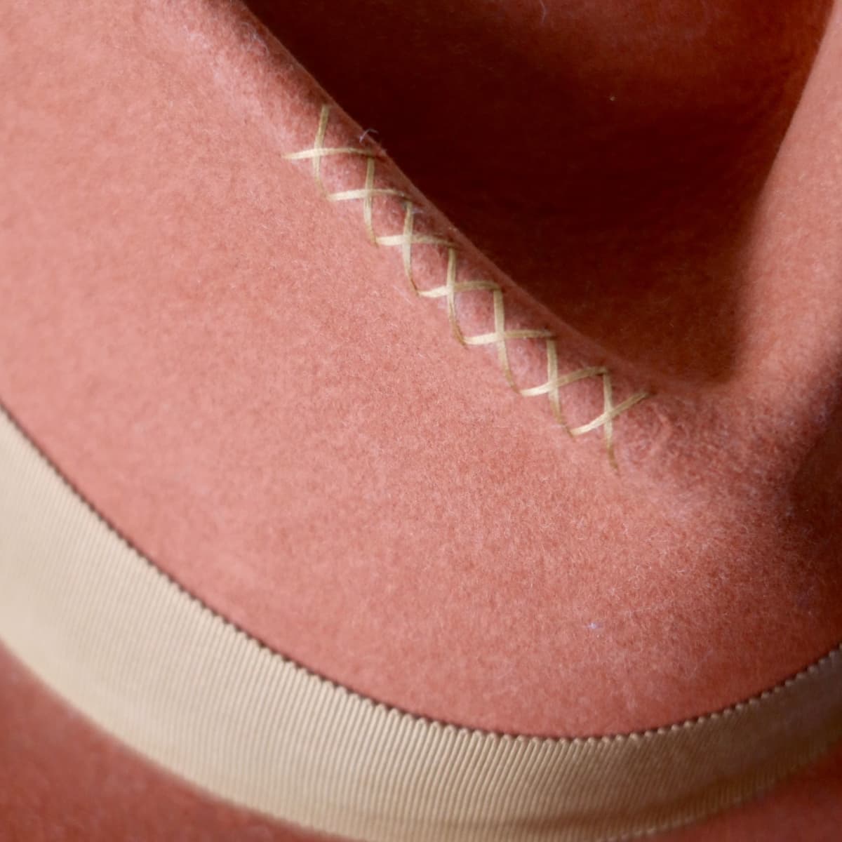 Close up detail of the Karratha felt hat showing hand-stitched cross detailing in copper thread.