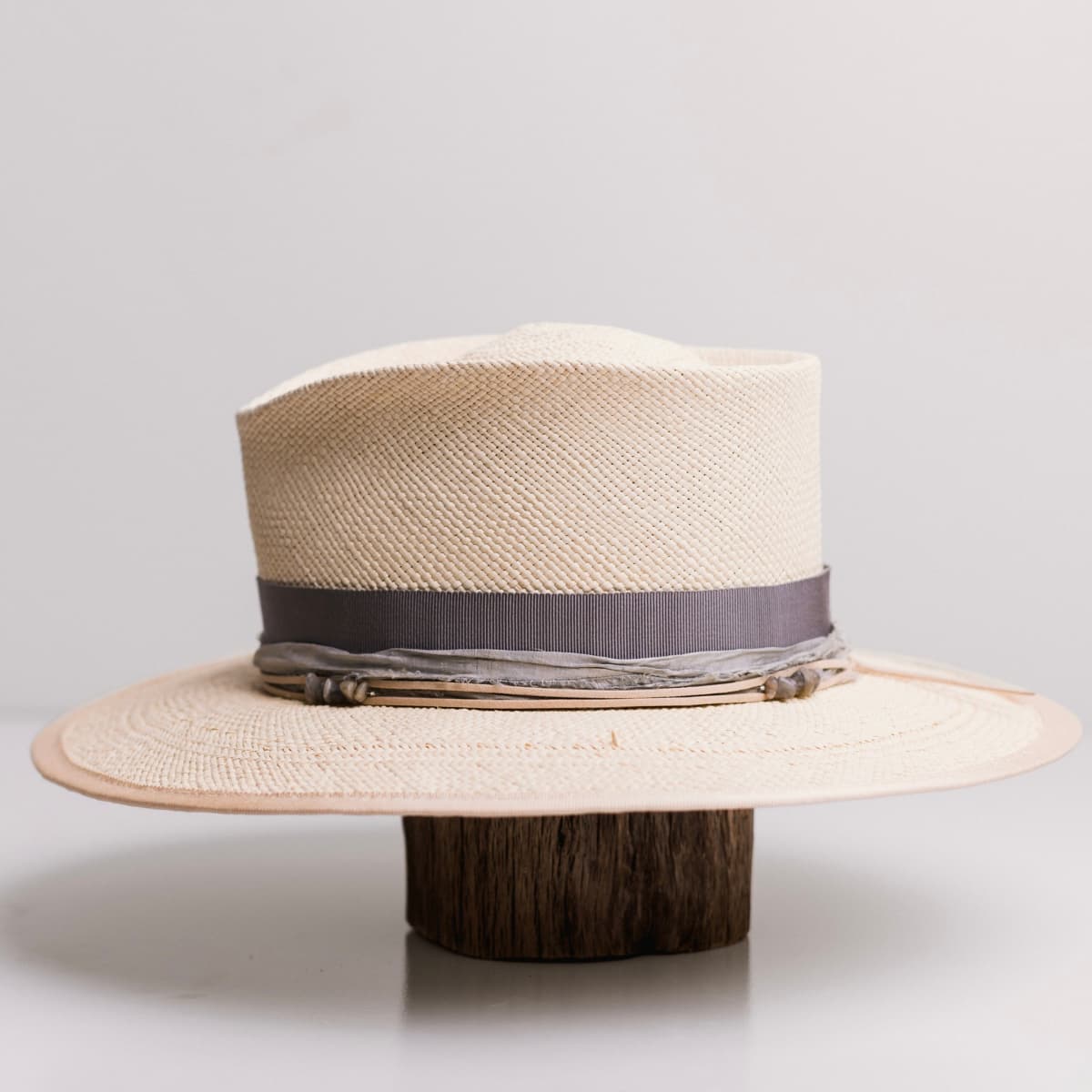 Left side view of the La Journee Natural Panama hat by PHYLLi Designs with cement Japanese grosgrain band, smokey quartz crystal clusters and nude suede string.