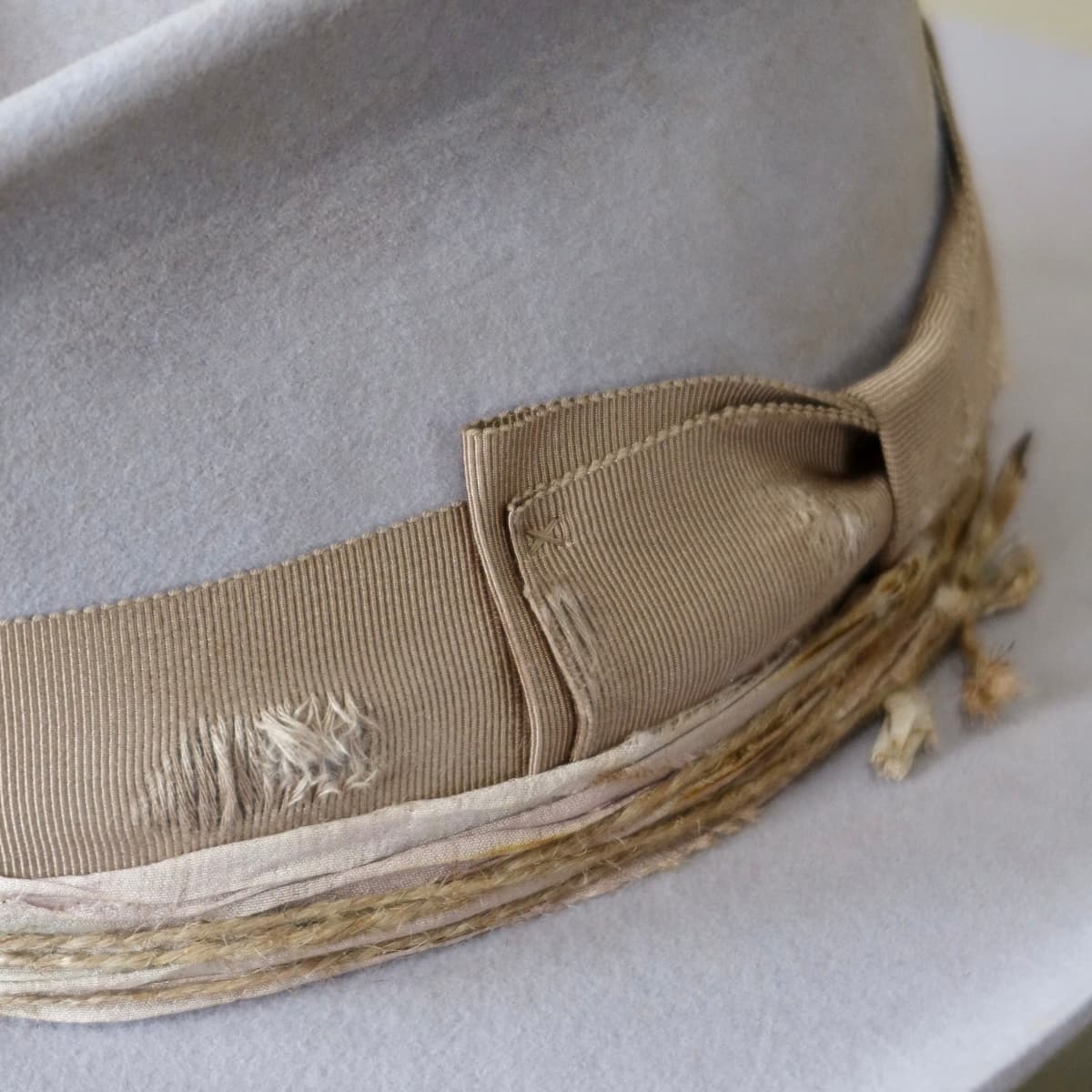 Close up detail of the Lacey cowgirl hat showing distressed Japanese grosgrain double bow band in taupe.
