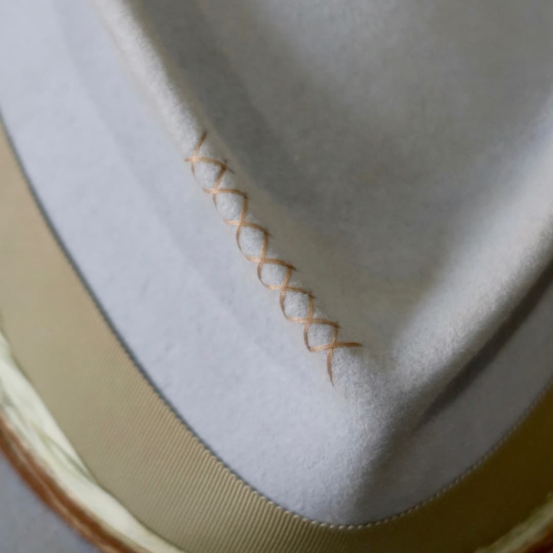 Close up detail of the Lagoon felt hat showing taupe hand-stitched cross detail on the crown.