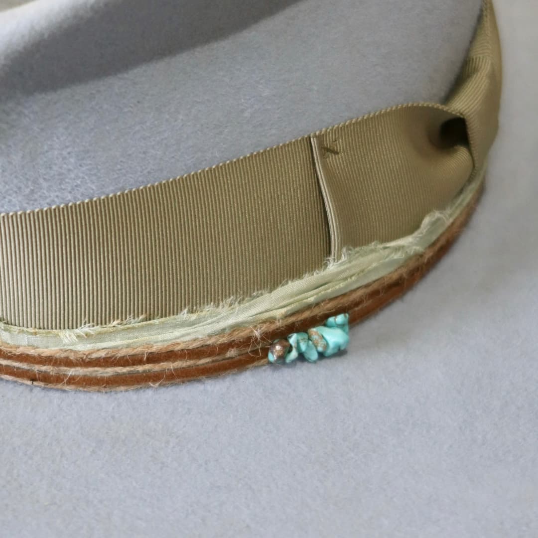 Close up detail of the Lagoon felt hat showing turquoise crystal cluster on the twine wrap.