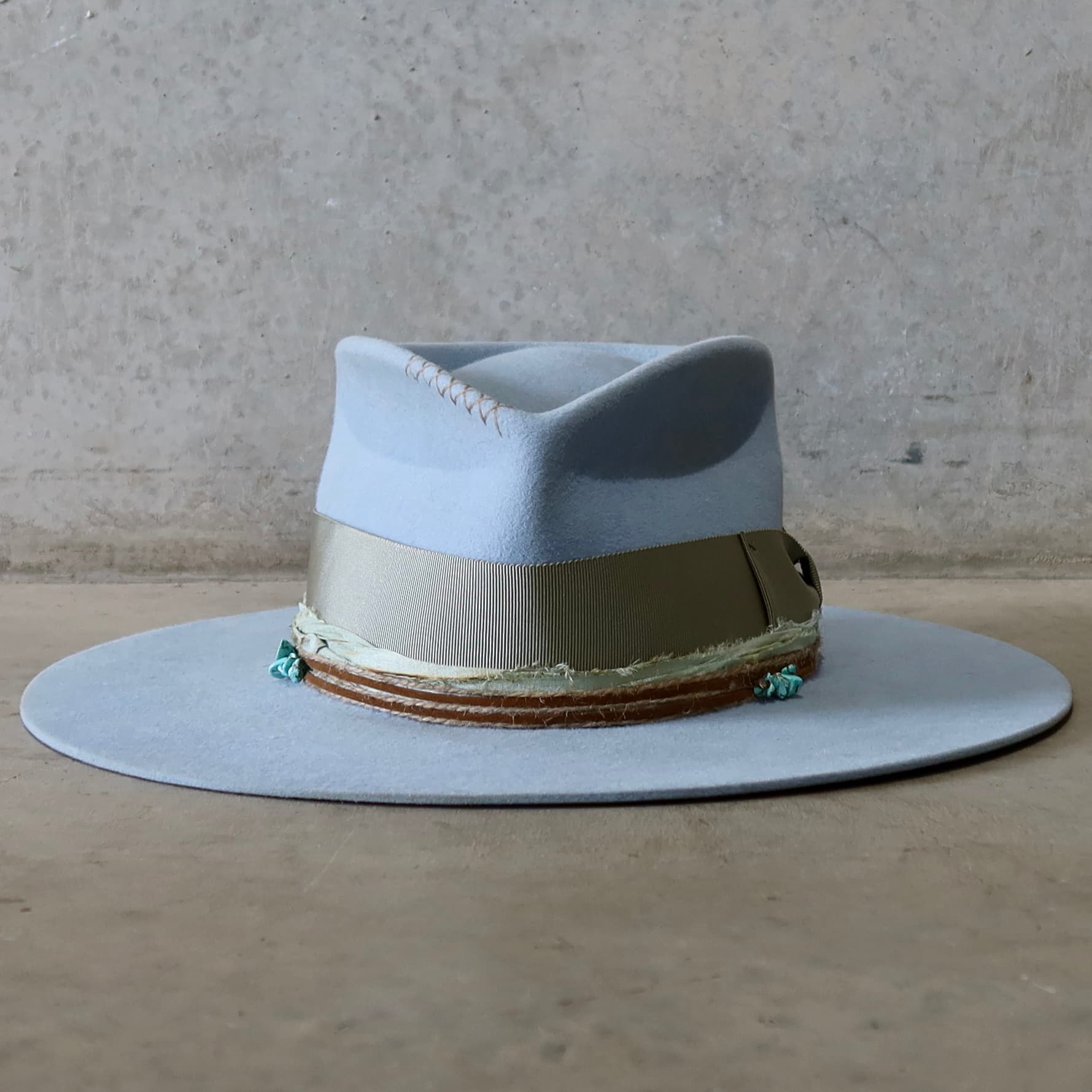 Crystal Blue felt hat Lagoon by PHYLLi Designs with oil green Japanese grosgrain bow band and turquoise crystal clusters.