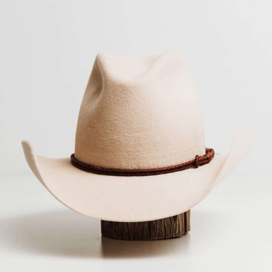 Laurie Hat Band featuring hand plaited dark brown kangaroo hide on a beige felt cowboy hat by PHYLLi Designs.