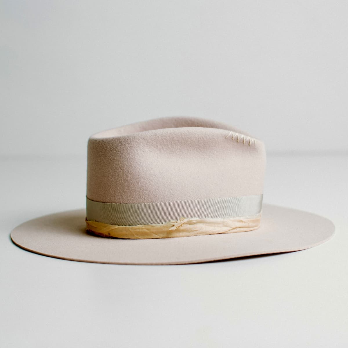 Right side view of light lilac felt hat with dove grey grosgrain band and sari silk trim by PHYLLi Designs.