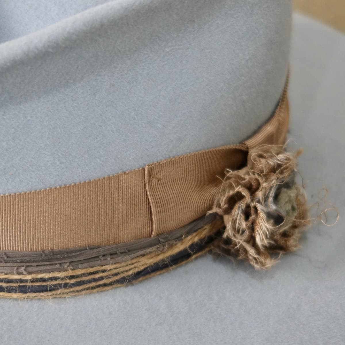 Close up detail of the Louise felt hat showing twine wraps and sari silk trimming around the crown.
