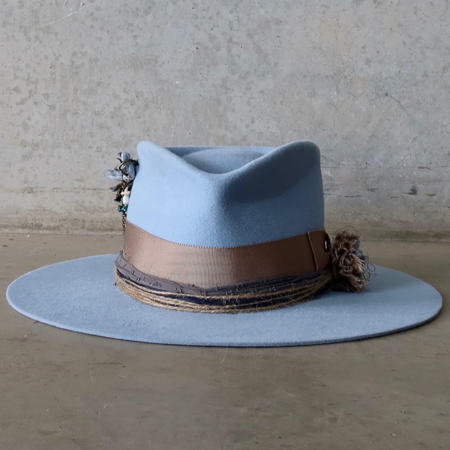 Crystal blue felt hat Louise by PHYLLi Designs with taupe Japanese grosgrain bow band and sari silk Lapel Blooms.