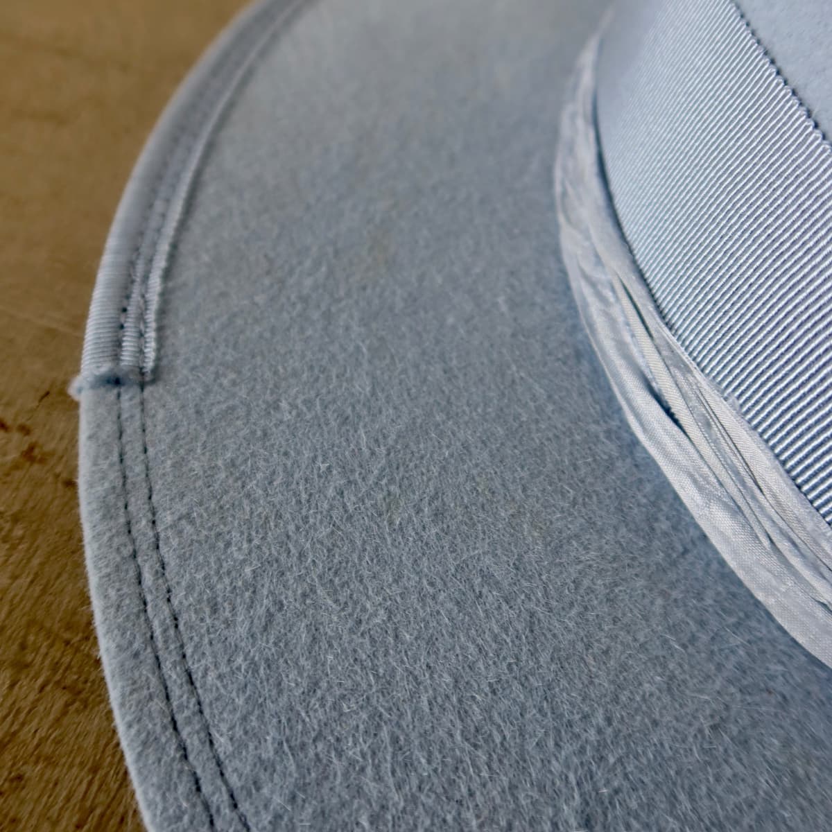 Close up detail of the Lucinda felt hat showing tonal blue double brim stitch and cornflower grosgrain brim trim.