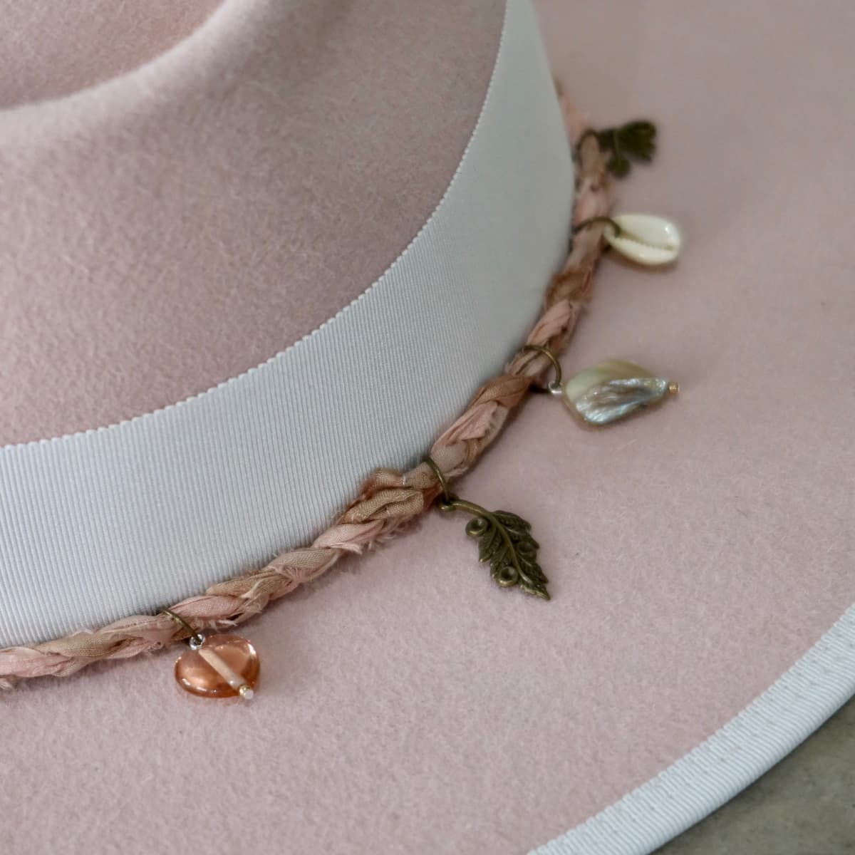 Close up detail of the Lucky Charm felt hat showing ivory tassel and charm details on the Charm Plait.