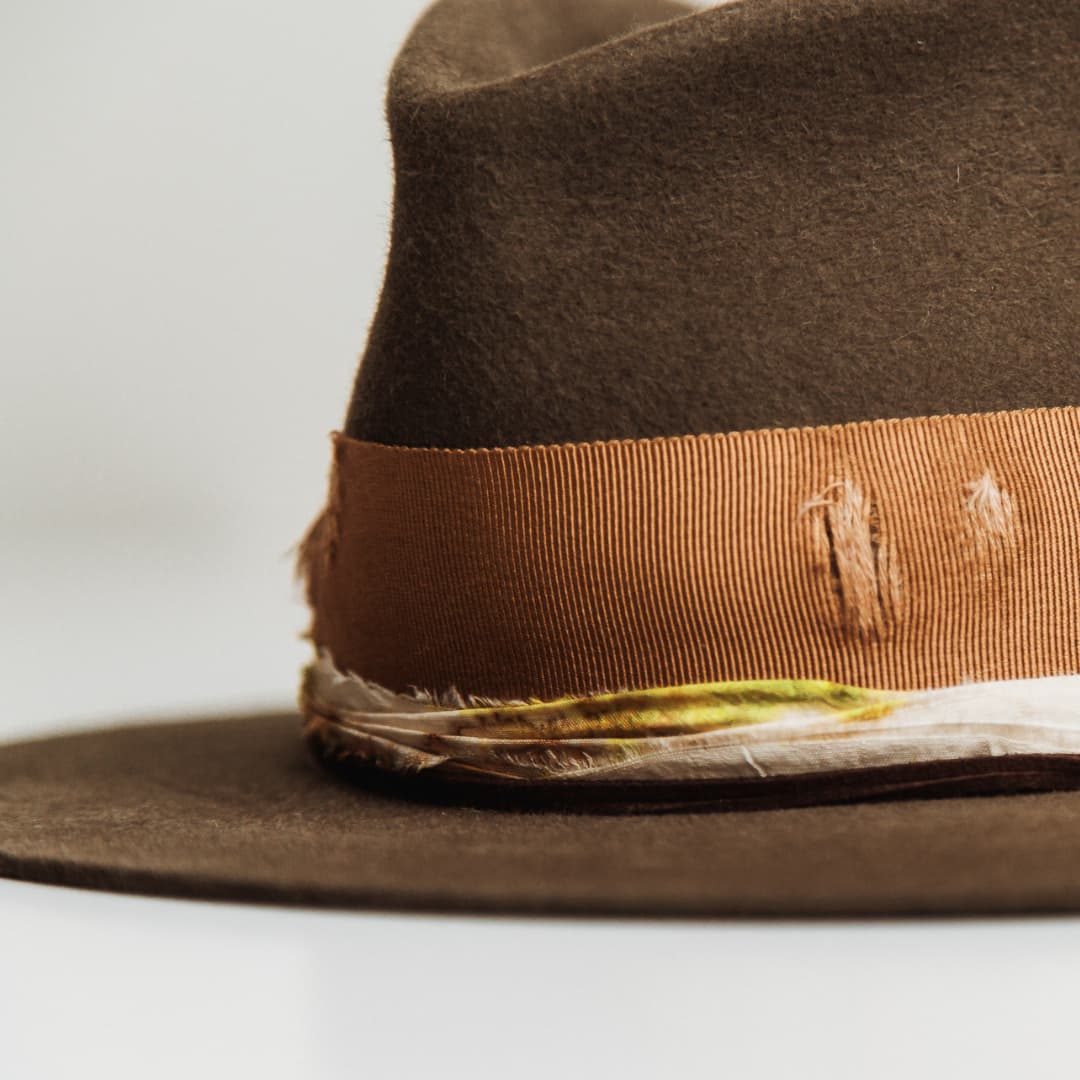 Close up detail of the Lucky Findings felt hat showing speckled cream and marigold sari silk trim wrapped around the crown.