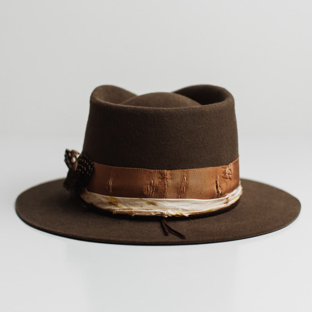 Back view of the Lucky Findings dirty olive felt hat by PHYLLi Designs featuring distressed copper grosgrain band with copper darned patches.