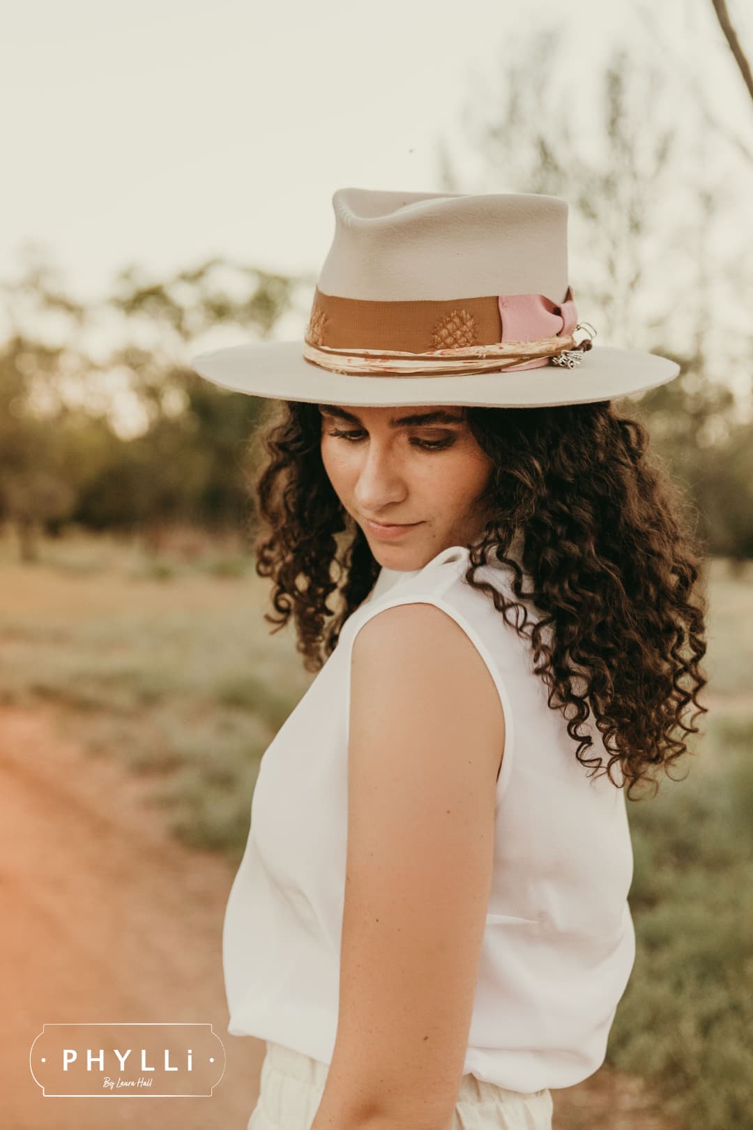 Sarah Wheeler wearing the Malibu beige felt hat by PHYLLi Designs with copper grosgrain band and sari silk trim.