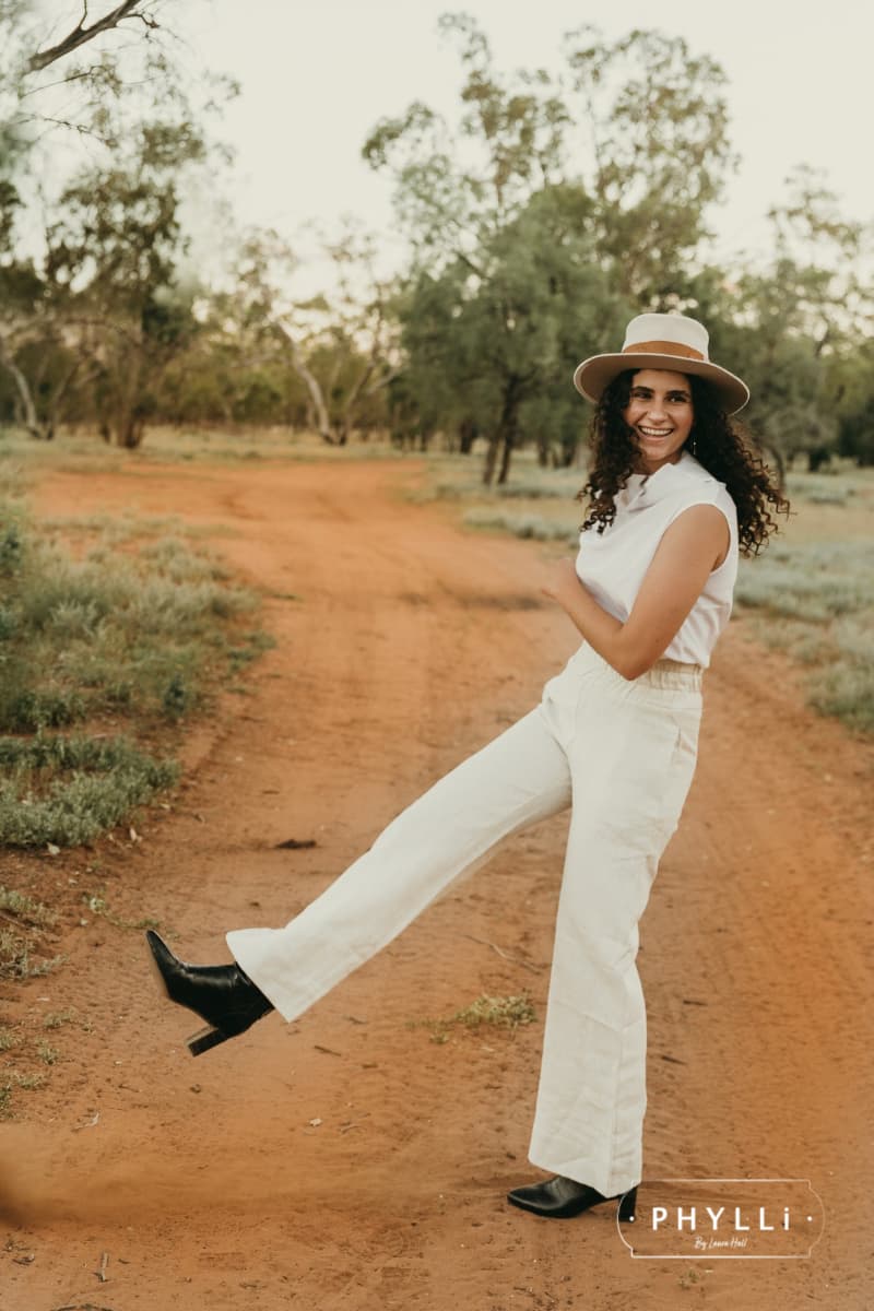 Sarah Wheeler wearing the Malibu beige felt hat by PHYLLi Designs standing on an outback road.